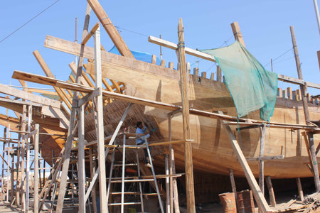 Sur, Oman, October 23, 2013: Man at work building a boat. Boat in Oman are built manually using woodのeditorial素材