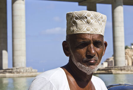 Sur, Oman, October 23, 2013: Omani fisherman at work. He is wearing the traditional omani hat, the kumma, used during unofficial time.のeditorial素材