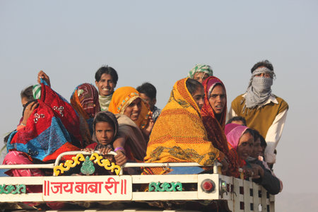 Pushkar, India, November 28, 2012: Indian People on a truck. Brightly colored sariのeditorial素材