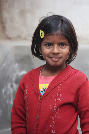 PUSHKAR, INDIA: Young Indian girl, red dressed, looking at the cameraのeditorial素材
