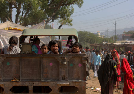 PUSHKAR, INDIA: Children on a truck in Pushkar, going to the famous Camel fair and smiling at the cameraのeditorial素材