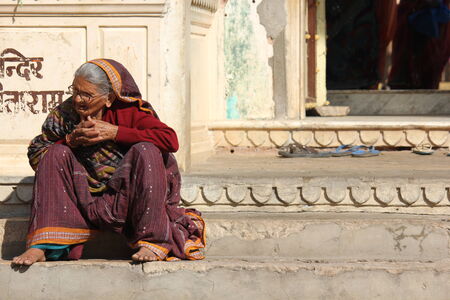 JAIPUR, INDIA: Old Indian woman sit outside a temple in Jaipur, barefoot.のeditorial素材