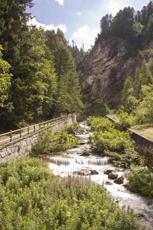 MADESIMO, ITALY - AUG 18 2014: Scenic landscape in Mdesimo, with a torent crossing the green natural place trough trees.のeditorial素材