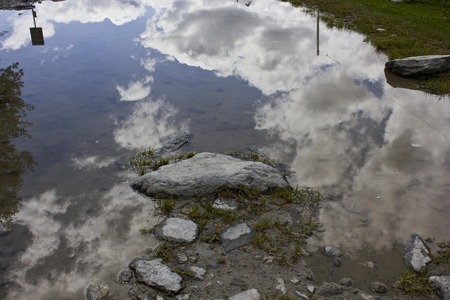 MADESIMO, ITALY - AUG 21 2014: Mountain path in Madesimo valley floor at summer, with mountain reflection in the puddle and and glacier のeditorial素材