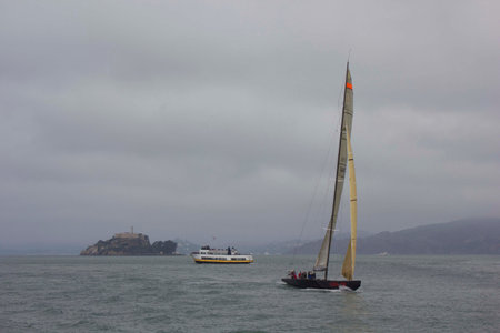 SAN FRANCISCO, USA - AUGUST 12 2013: Sailing in San Francisco. Sailing boat on the Pacific ocean with Alcatraz Insland in the background in a dull day.のeditorial素材