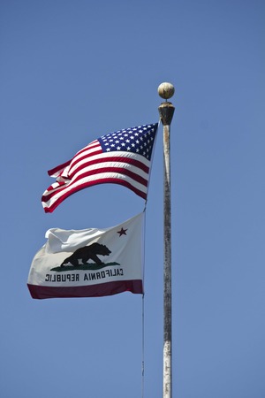 SAN DIEGO, USA - AUGUST 22 2013: American and California flags waving on the blue skyのeditorial素材