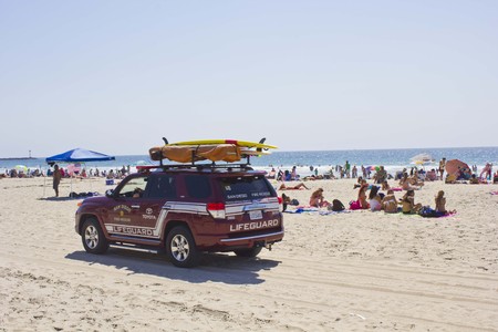 SAN DIEGO, USA - AUGUST 22 2013: Lifeguard vehicle on Mission Bay Beach with people in San Diego, Californiaのeditorial素材