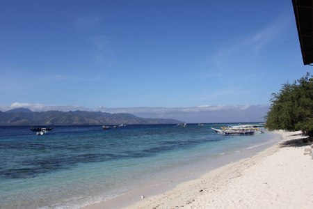 GILI ISLANDS, INDONESIA - JULY 9 2012: Gili Islands Beach in Indonesia with no people around and some boats on the seaのeditorial素材