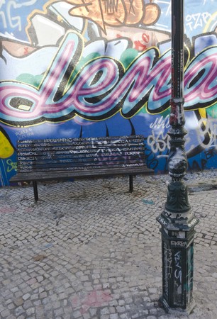 LISBON, PORTUGAL - OCTOBER 25 2014: A bench and a light pole in Calcado do Lavra street in Lisbon, full with graffiti on the wallのeditorial素材