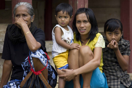 RANTEPAO, INDONESIA - JULY 3 2012: Portrait of a poor Torajan family outside their house in Rantepao, Indonesiaのeditorial素材