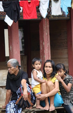 RANTEPAO, INDONESIA - JULY 3 2012: Portrait of a poor Torajan family outside their house in Rantepao, Indonesiaのeditorial素材