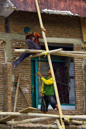 SULAWESI, INDONESIA - JULY 2 2012: Indonesian workers in a construction site in the South Sulawesi, with no safety equipment, working on bamboo canesのeditorial素材