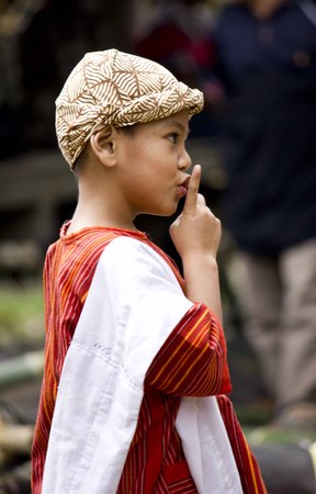 TANA TORAJA, INDONESIA - JULY 3 2012: Young Indonesian boy saying shh during a funeral ceremony in Indonesia. Close up.のeditorial素材