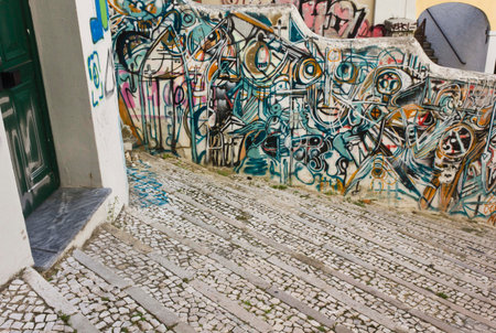LISBON, PORTUGAL - OCTOBER 25 2014: Graffiti on Calcada do Lavra street in Lisbon, Portugal, along a stairway with a doorのeditorial素材