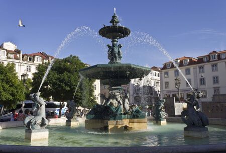 LISBON, PORTUGAL - OCTOBER 23 2014: Monumental fountain in Rossio Square in Lisbon, with few people around and a bus in the backgroundのeditorial素材
