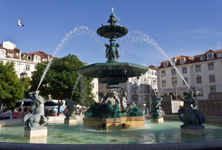 LISBON, PORTUGAL - OCTOBER 23 2014: Monumental fountain in Rossio Square in Lisbon, with few people around and a bus in the backgroundのeditorial素材