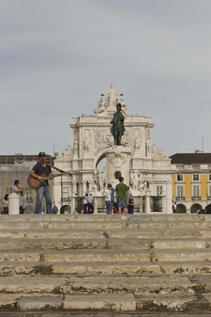 LISBON, PORTUGAL - OCTOBER 24 2014: Street singer in Commerce square in Lisbon, with the equestrian statue and triumphal arch in the background and people aroundのeditorial素材