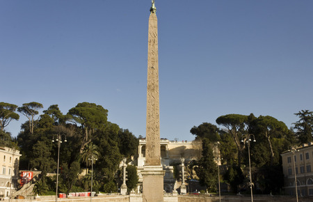 ROME, ITALY - DECEMBER 31 2014: The Egyptian obelisk of Ramesses II in Piazza del Popolo in Rome, Italy, surrounded by treesのeditorial素材