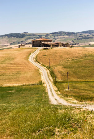 VAL D'ORCIA , ITALY - JUNE 3 2017: Tuscan Hills countryside, with a small rural house in the backgroundのeditorial素材
