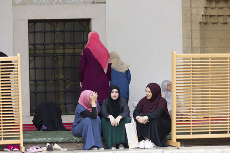 SARAJEVO, BOSNIA AND HERZEGOVINA - AUGUST 20 2017: three islamic girls sit in the courtyard of Gazi husrev beg Mosque in Sarajevoのeditorial素材