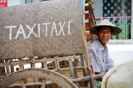 Myanmar taxi with bamboo wagon and a man driving a cowのeditorial素材