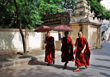 three monks walking in a monastry street in Mandalay, Myanmar (Burma)のeditorial素材