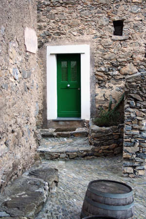 green door in old stone town in northern Italy on the hillの写真素材