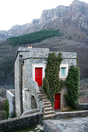 little rural stone house in mountain with coloured doorのeditorial素材