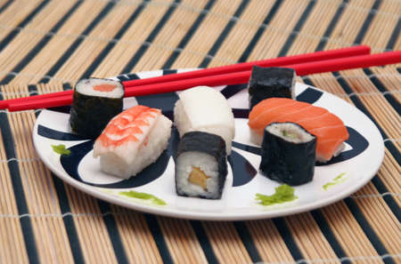 sushi plate with red chopsticks on bamboo tableclothの写真素材