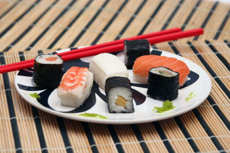 sushi plate with red chopsticks on bamboo tableclothの写真素材