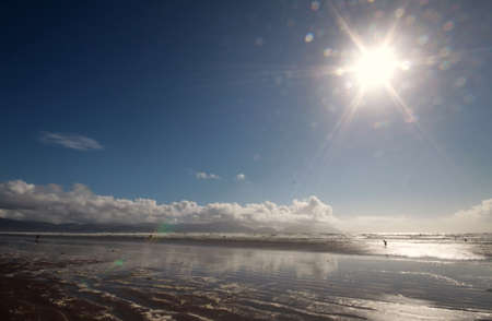 Sun and wet sand on beach at Inch Castlemaine town in Irelandの写真素材