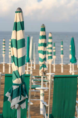 closed umbrellas and chairs on the beachの写真素材
