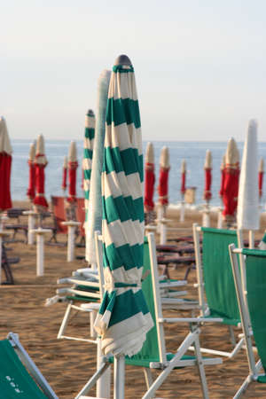 closed umbrellas and chairs on the beachの写真素材