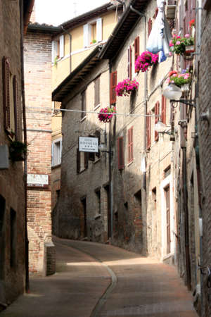 typical lane with reb bricks downtown historical houses in Urbino, Italyのeditorial素材