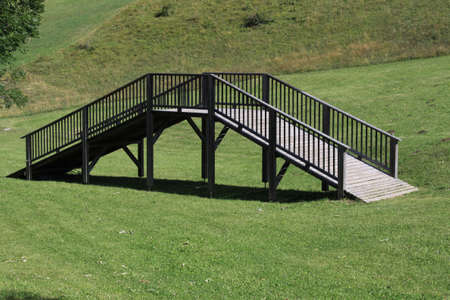 Wooden bridge crossing nothing, put on a meadow in Folgaria, Trentino, Italyの写真素材