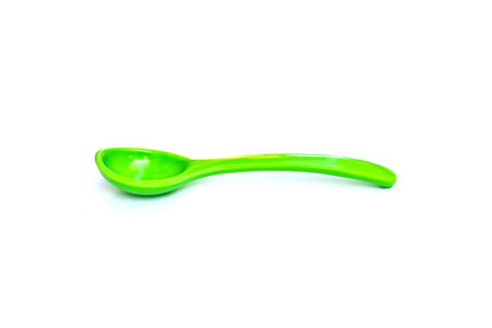 Green plastic spoon on white backgroundの写真素材