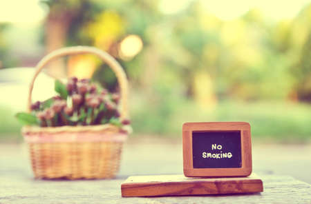 Vintage no smoking sign with artificial flowers on wooden dining tableの写真素材
