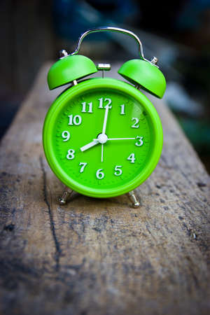 Vintage green alarm clock on wooden.の写真素材