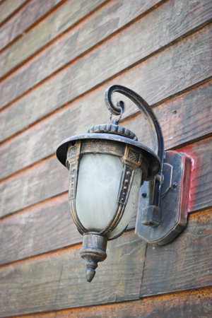 Classic lamp hanging on old wooden wallの写真素材