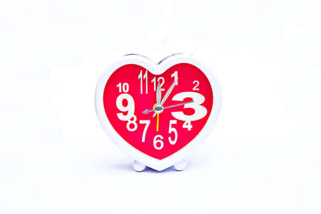 Pink clock shaped heart on white background.の写真素材