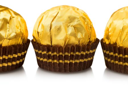 Candy in gold wrappers, isolated on white backgroundのeditorial素材