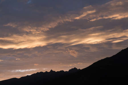 Sunset's light makes clouds looks golden in sky.の写真素材