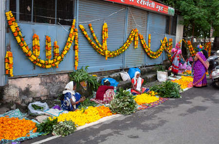 Women selling marigold flowers and garlands on the street on the eve of the festival of Dasara or Vijayadashami Location: Nashik, Maharashtra, India Date: October 24 2020のeditorial素材