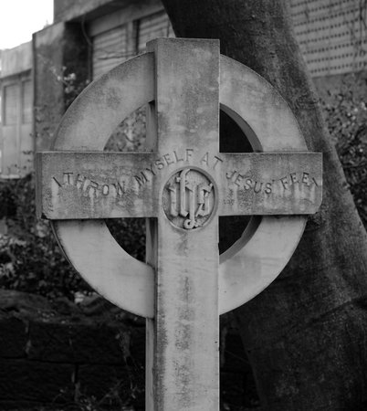 Inscription in a marble cross of an old unmaintained grave - with the words I throw myself at Jesus'...