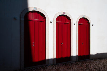 Red doors on a white wall in the old town of Tagus Port Belem Lisbonの写真素材