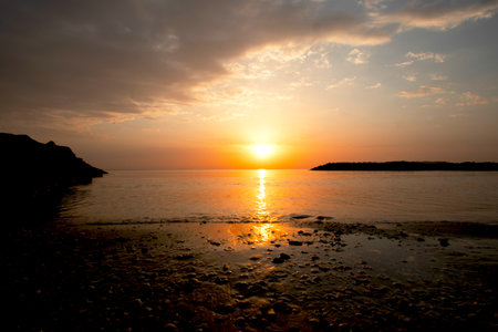 Beautiful sunset on the sea. The sun sets over the sea.の写真素材