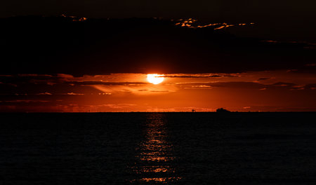 Sunset over the sea. Silhouette of a ship at sunset.の写真素材