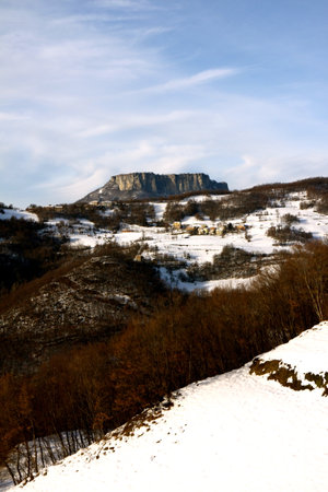 Mountain landscape in winter. The breathtaking beauty of the Tuscan-Emilian Apennine hills with Bismantova Rock in the distanceの写真素材