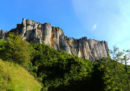 Mountain landscape with blue sky and white clouds, closeup of photo. The Breathtaking Beauty of the Tuscan-Emilian Apennine Hills with Bismantova Rock in the Distanceの写真素材