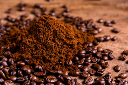 Coffee beans and ground powder on wooden background. Selective focus.の写真素材